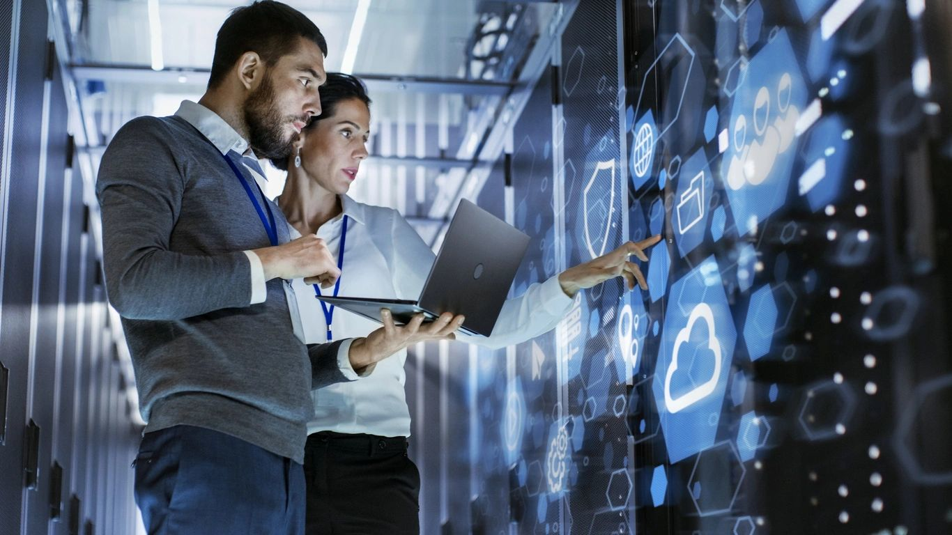 Two professionals reviewing data in a server room